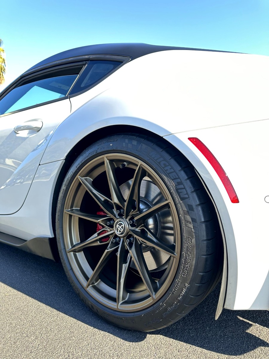 Bronze wheel on white sports car